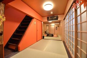 um corredor com uma parede laranja e uma escada em Kyoto - House - Vacation STAY 88802 em Quioto