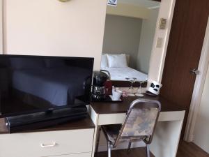 Kleines Zimmer mit einem Bett und einem TV in der Unterkunft Motel de la Pente Douce in Magog-Orford