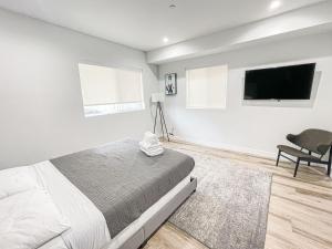 a bedroom with a bed and a flat screen tv at Spacious 4BR Townhouse in Mid City - WH-C2 in Los Angeles