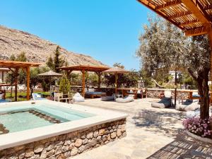 a swimming pool in a yard with a patio at Caesars Gardens Hotel & Spa - Adults Only in Lindos