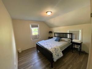 a bedroom with a bed and a table and a window at The Water Street Inn in Napanee