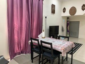 uma sala de jantar com uma mesa e uma cortina rosa em Rosevilla Homestay - 3R2B Fully Aircond WiFi em Bandar Puncak Alam
