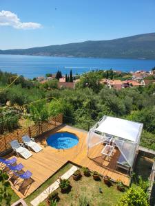 a backyard with a pool and chairs and a tent at Sunrise Apartments Baošići in Herceg-Novi