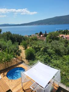 a pool on a deck with a view of the water at Sunrise Apartments Baošići in Herceg-Novi