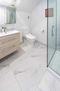 ein Bad mit einem WC und einer Glasdusche in der Unterkunft Cashel Street Hideaway 2 bed 2 bath in Christchurch