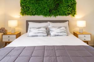 ein Schlafzimmer mit einem weißen Bett mit zwei Lampen in der Unterkunft Cashel Street Hideaway 2 bed 2 bath in Christchurch