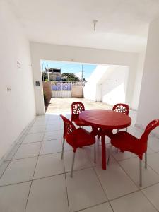 comedor con mesa roja y sillas en Pousada Aconchego Sol e Mar, en Maragogi