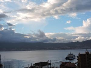 Una barca in acqua sotto un cielo nuvoloso di Art & Music B&B a Villa San Giovanni