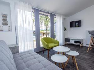 a living room with a couch and two tables and a green chair at Hillside Haven in Waxweiler in Waxweiler
