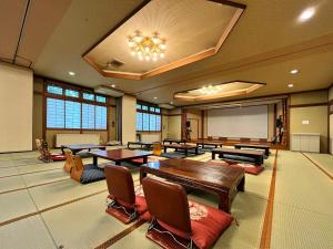 una sala de conferencias con mesas y una pantalla de proyector en Guest Room Furusatomura Kogeikan en Omachi
