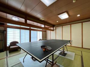 una mesa de ping pong con un sombrero encima en Guest Room Furusatomura Kogeikan en Omachi