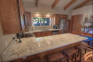a kitchen with a granite counter top and wooden cabinets at Cozy Bear Lodge home in Incline Village