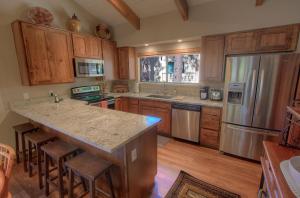 una cocina con armarios de madera y una isla de cocina con taburetes en Cozy Bear Lodge home, en Incline Village 42 fotos más