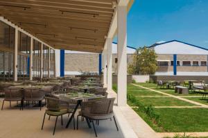 a patio with tables and chairs on a lawn at Four Points by Sheraton Nairobi Airport in Nairobi