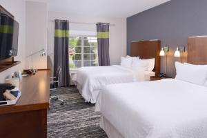 a hotel room with two beds and a television at Four Points By Sheraton Mount Prospect O’Hare in Mount Prospect