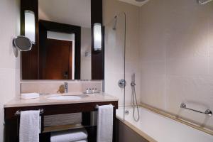 uma casa de banho com um lavatório e uma banheira em Sheraton Batumi Hotel em Batumi