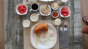 a table with a plate of food with eggs and bread at Lava House Hostal in Puerto Ayora