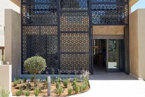 a facade of a building with a courtyard with plants at Domes Noruz Chania, Autograph Collection- Adults Only in Kato Daratso