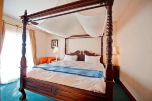 a bedroom with a four poster bed with a canopy at Protea Hotel by Marriott Walvis Bay Pelican Bay in Walvis Bay