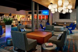 a lobby with chairs and a table and a bar at Aloft Hotel Calgary University in Calgary