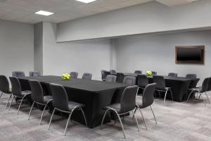 einen Konferenzraum mit einem schwarzen Tisch und Stühlen in der Unterkunft Aloft Hotel Calgary University in Calgary