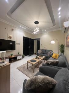 ein Wohnzimmer mit 2 Sofas und einem TV in der Unterkunft تل النسيم Hill Breeze in Abha