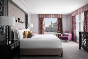 a bedroom with a large white bed and a purple chair at The Ritz-Carlton, New Orleans in New Orleans