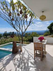 una mesa y una silla junto a un árbol junto a una piscina en CASA SIRENA Montaña, Alberca y Hermosa vista, en San Andrés Huayapan