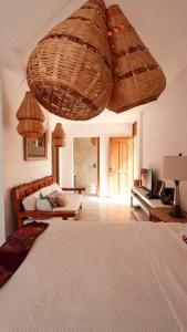 een slaapkamer met een bed en rieten manden aan het plafond bij CASA SIRENA Montaña, Alberca y Hermosa vista in San Andrés Huayapan