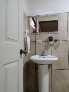 La salle de bains est pourvue d'un lavabo blanc et d'un téléphone. dans l'établissement Hotel Santa Fe B&B, à Monteverde Costa Rica