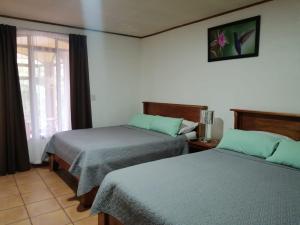 - une chambre avec 2 lits et une fenêtre dans l'établissement Hotel Santa Fe B&B, à Monteverde Costa Rica