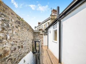 una pared de ladrillo junto a un edificio blanco con una puerta en The Coffee House en Coleford