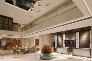 eine Lobby eines Hotels mit einem Tisch und Stühlen in der Unterkunft Four Points by Sheraton Hotel and Serviced Apartments Pune in Pune