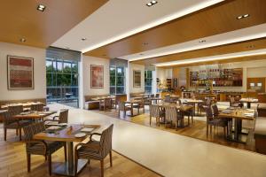 a dining room with tables and chairs and a restaurant at Four Points by Sheraton Hotel and Serviced Apartments Pune in Pune
