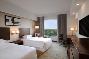 Postel nebo postele na pokoji v ubytování Four Points by Sheraton Hotel and Serviced Apartments Pune