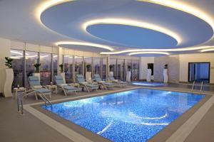 un hall avec une grande piscine et des chaises dans l'établissement Marriott Executive Apartments Madinah, à Médine