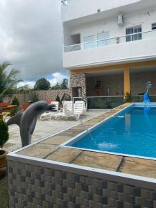 a dolphin statue next to a swimming pool at Pousada Tropical Paulo Afonso in Paulo Afonso