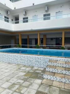 - un bâtiment avec une piscine à côté d'un bâtiment dans l'établissement Pousada Tropical Paulo Afonso, à Paulo Afonso