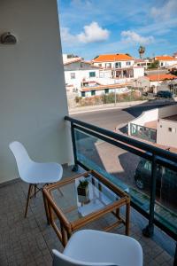 uma varanda com uma cadeira branca e vista para uma rua em Villas Horizonte Capazi em Porto Santo