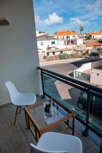 a balcony with a white chair and a view of a street at Villas Horizonte Capazi in Porto Santo