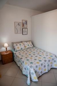 a bedroom with a bed with a comforter on it at Villas Horizonte Capazi in Porto Santo