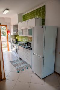 cocina con nevera blanca y lavavajillas en Villas Horizonte Capazi en Porto Santo