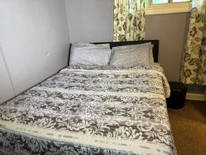 uma cama com um edredão e almofadas preto e branco em Beautiful SLC apartment in the avenues em Salt Lake City