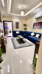 sala de estar con sofá azul y mesa en الجوهرة الزرقاء بجوار فعاليات سما أبها, en Abha