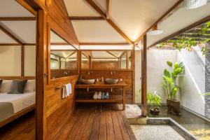a bathroom with a bed and two sinks in a room at Gili Teak Beach Front Resort in Gili Trawangan