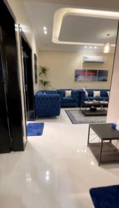 a living room with a blue couch and a table at الجوهرة الزرقاء بجوار قرية السماء - سما أبها in Abha
