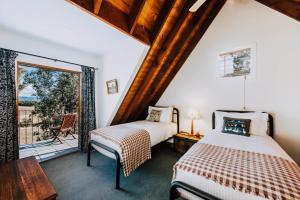 a bedroom with two beds and a balcony at Apple Tree Cottage - An Idyllic Country Reset in Mudgee