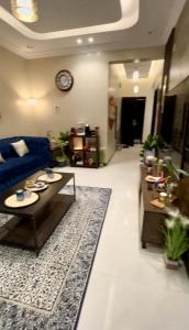 a living room with a blue couch and a rug at الجوهرة الزرقاء بجوار قرية السماء - سما أبها in Abha