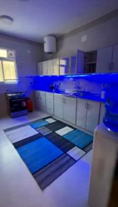 a large kitchen with blue lights on the counters at الجوهرة الزرقاء بجوار قرية السماء - سما أبها in Abha