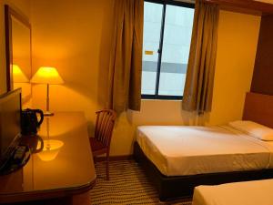 a hotel room with a bed and a window at Oxford Hotel in Singapore